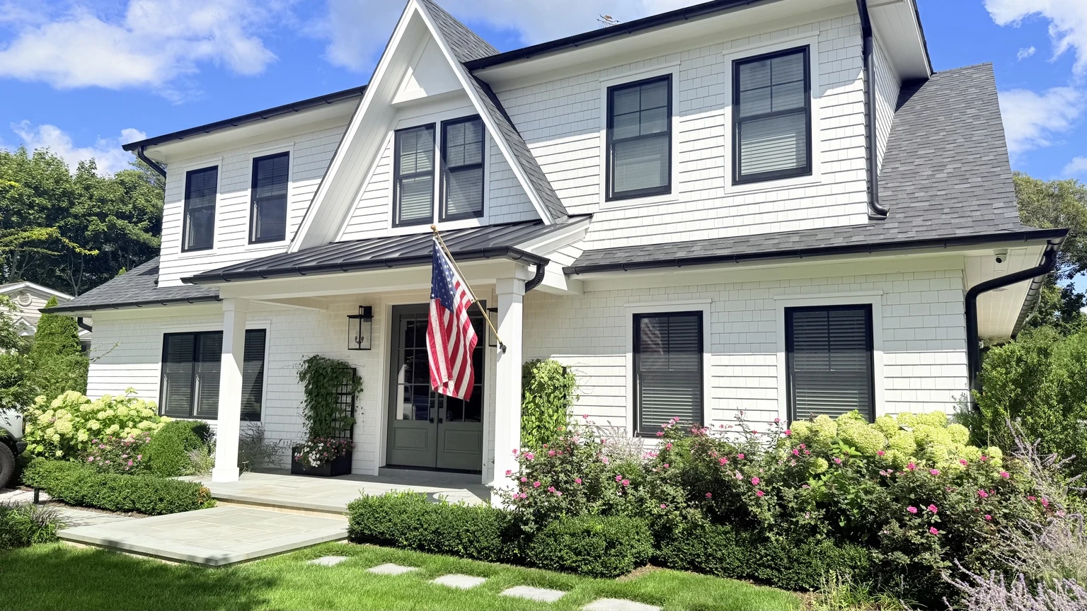 White Long Island home with black trim and landscaped front yard